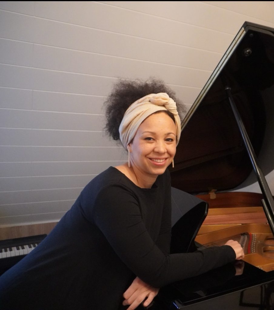 Frau lächelt am Klavier