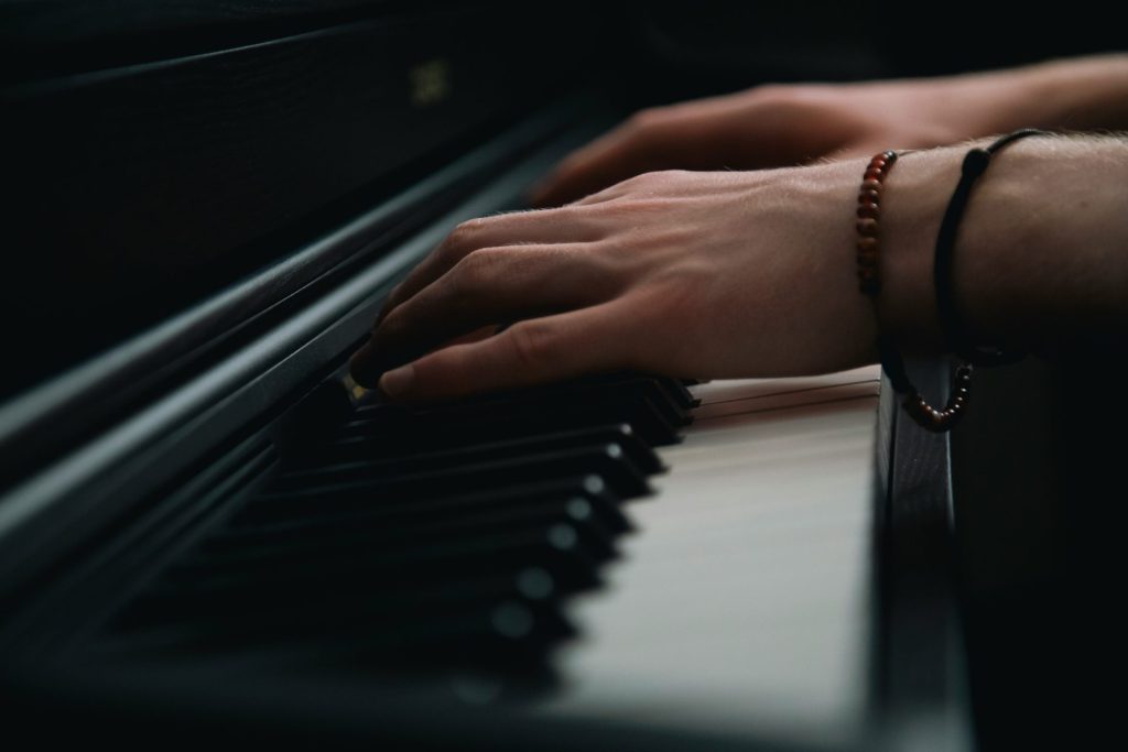 Nahaufnahme einer Person, die Klavier spielt